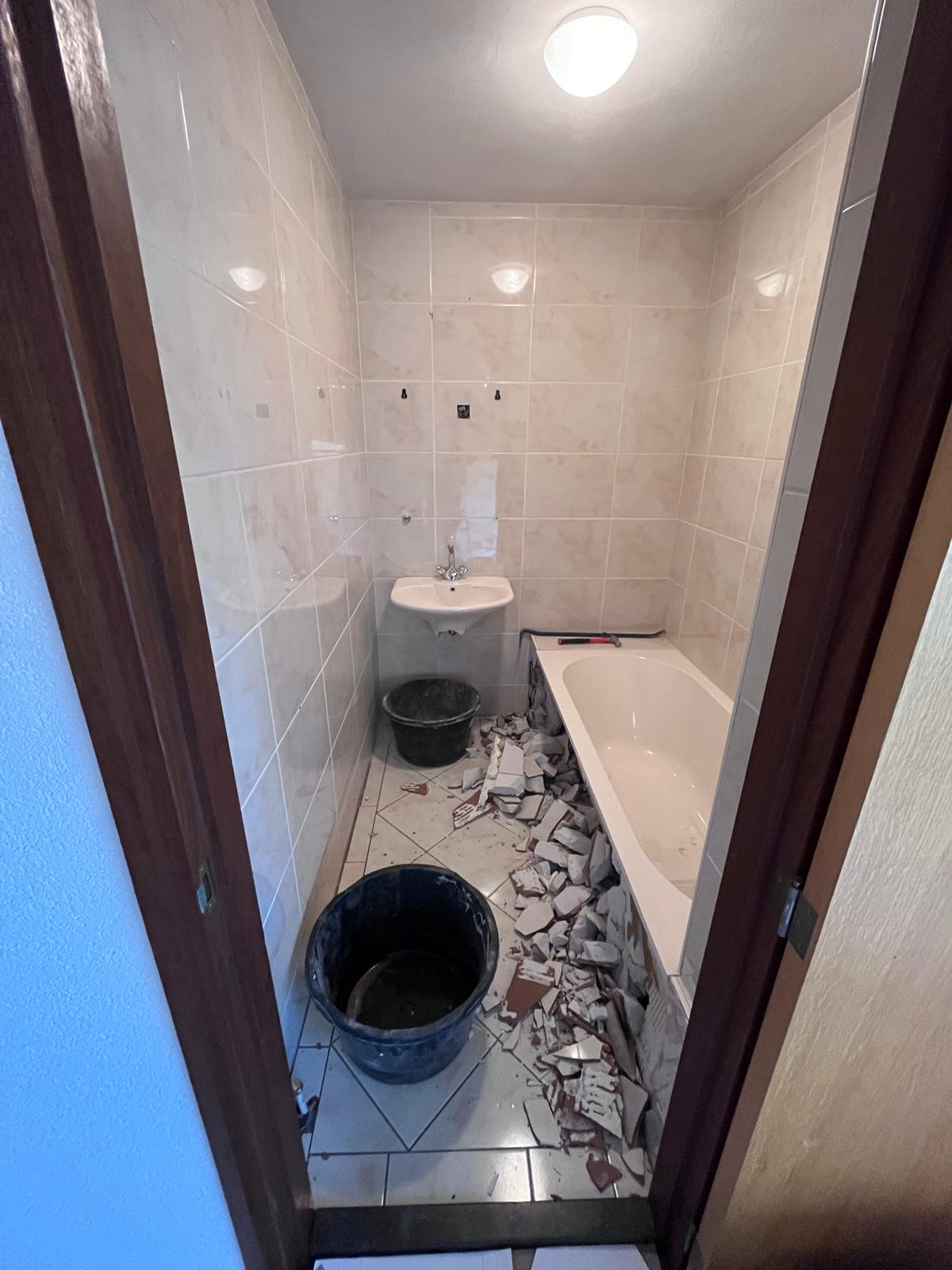 Situatie voor: badkamer tijdens de sloopwerkzaamheden met losgebroken tegels en puin